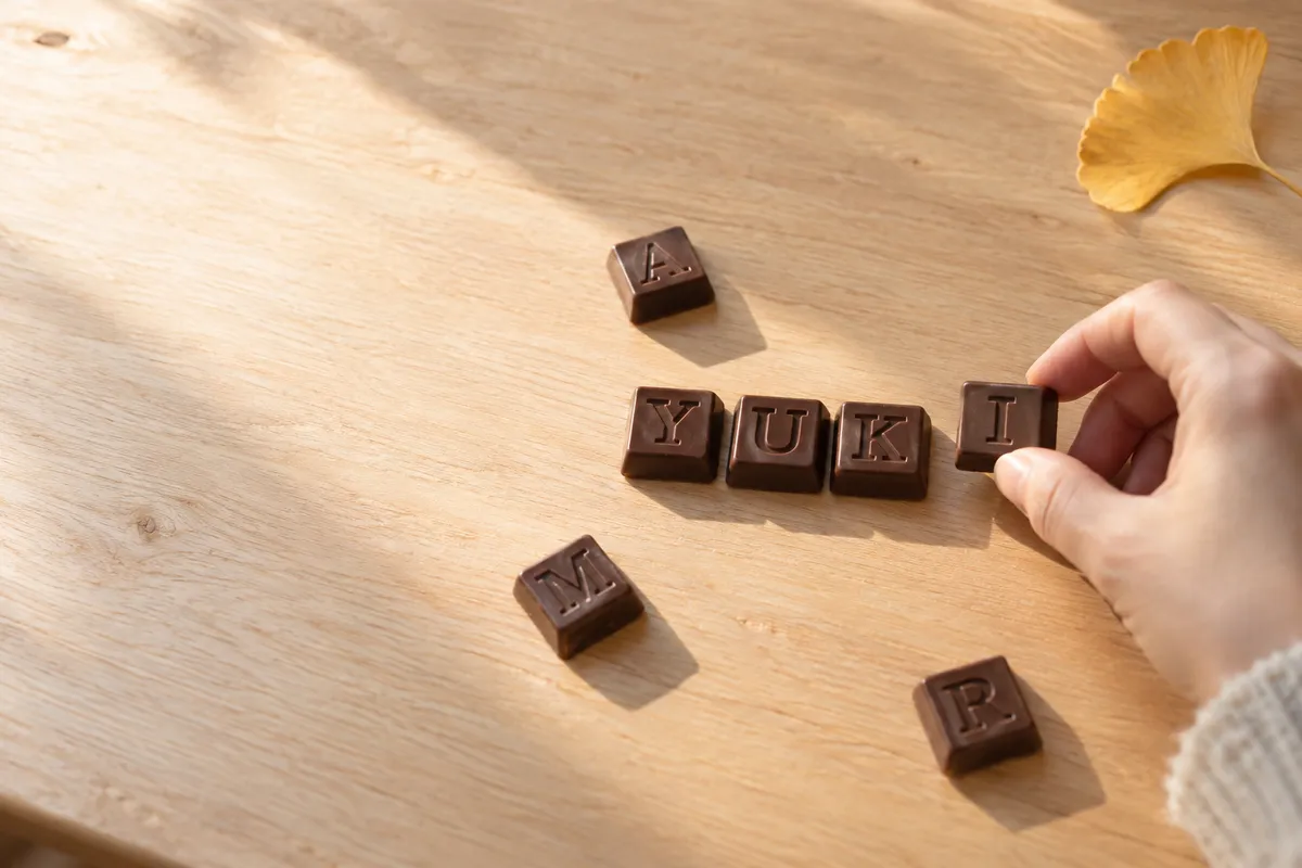 机にアルファベットのチョコを並べる手元
