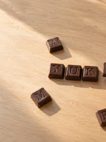 机にアルファベットのチョコを並べる手元