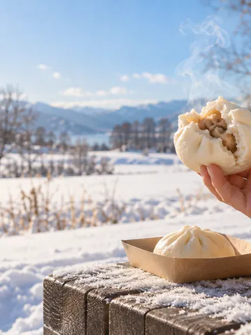 雪の日なたで湯気の立つ中華まんを持つ手元