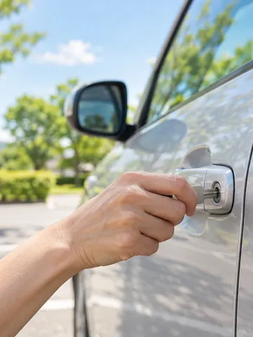 晴れた駐車場で車のドアに鍵をかける手元