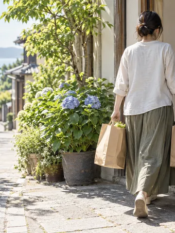 買い物袋の人のために扉を押さえる手