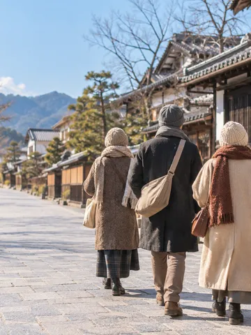冬の晴れた街でガイドの後ろを歩く見学の一行