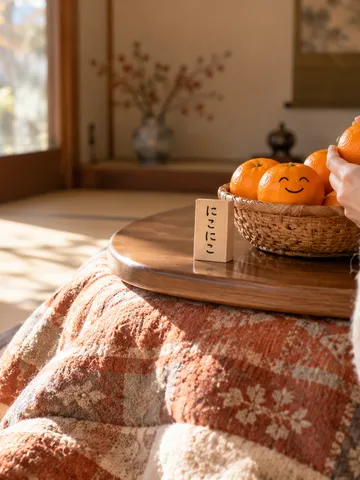 こたつの上の笑顔のみかんと「にこにこ」の木札