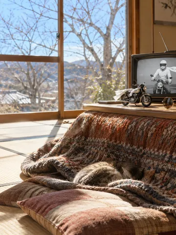 こたつの上の古いテレビとおもちゃのバイク、みかん