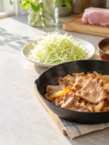 台所の調理台に並ぶ豚の生姜焼きと豚汁
