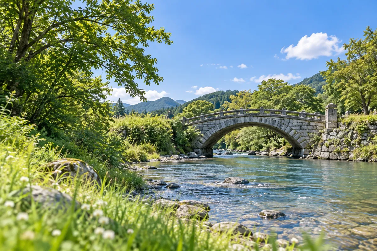 夏の川にかかる石造りのアーチ橋