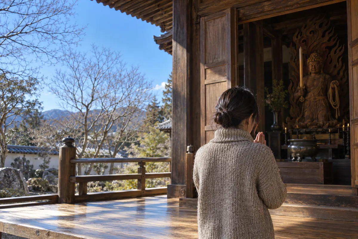 晴れた冬の日に不動堂へ手を合わせる後ろ姿