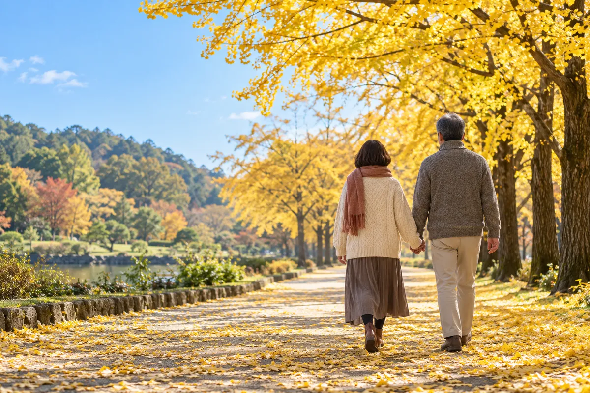 銀杏並木を手をつないで歩く夫婦の後ろ姿