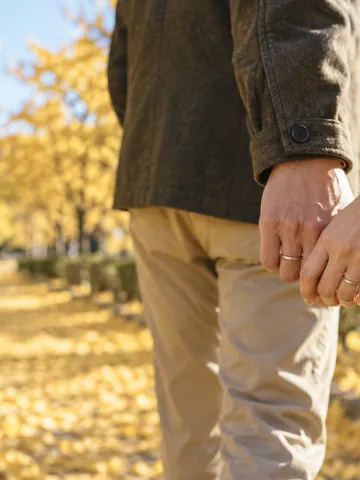 紅葉の道で手をつなぐふたりと、手元の指輪