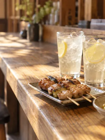 日だまりの居酒屋カウンターに並ぶ酎ハイと料理