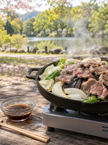 屋外のテーブルで羊肉と野菜を焼くジンギスカン鍋