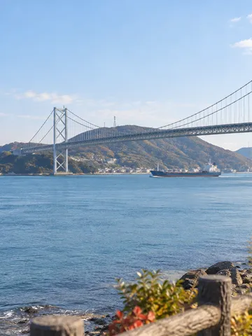 晴れた日の関門海峡と関門橋、橋の下を進む船