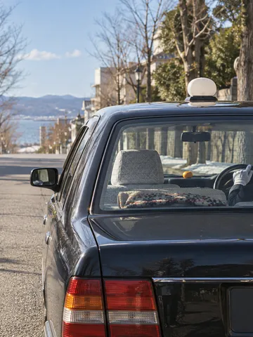 冬の晴れた日、後部座席から見たタクシーの運転席と手元