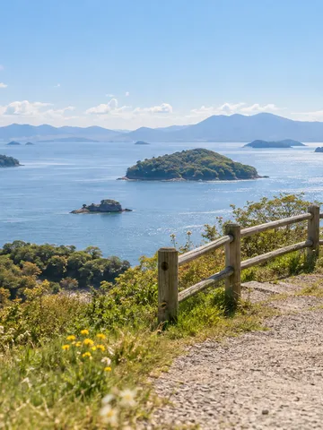 日なたの遊歩道から眺める穏やかな島々の海