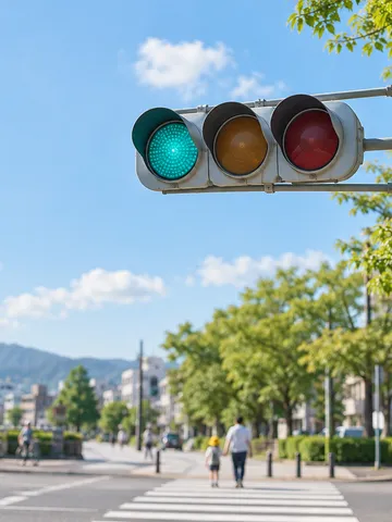 夏空の下で青を灯す交差点の信号機