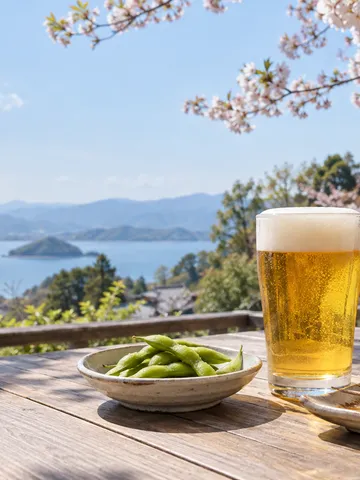 桜の下のテラス席に置かれた生ビールと枝豆
