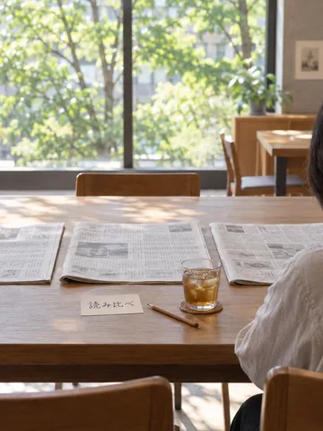 図書館の机に並ぶ3紙と「読み比べ」の札