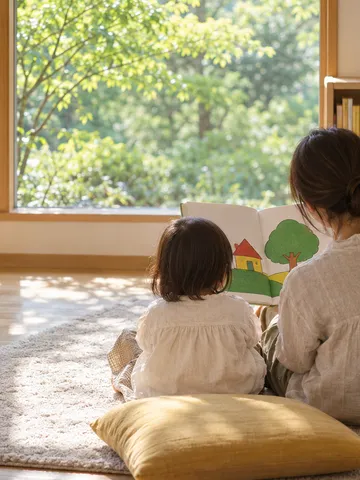 図書館で親子が絵本を開いている後ろ姿