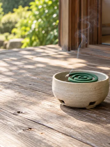 ベランダの床で煙を上げる蚊取り線香と虫ケアの木札