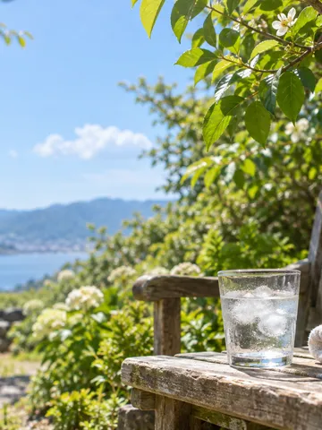 初夏の庭の木札と冷たい水のグラス、タオル