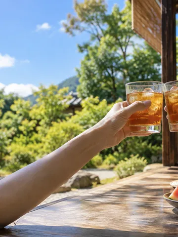 縁側で麦茶のグラスを乾杯する手元