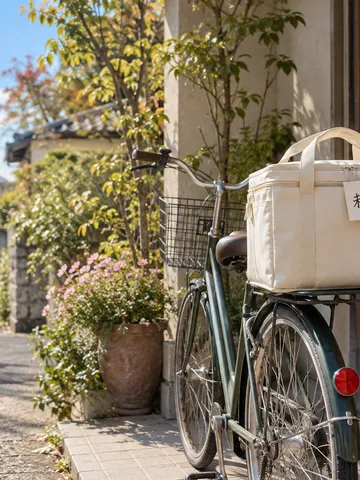玄関脇の自転車の配達バッグに「未来体験」の札