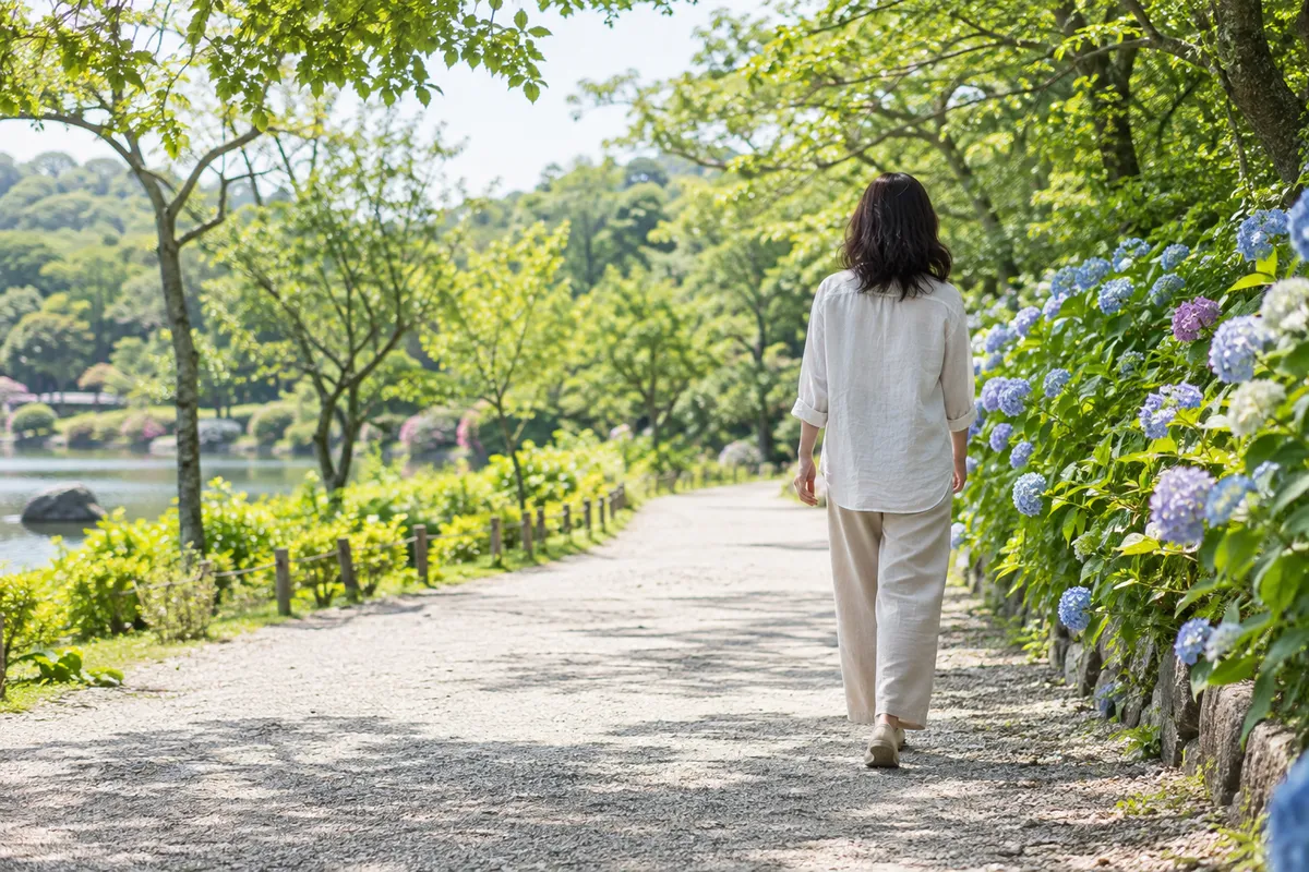 初夏の並木道をまっすぐな姿勢で歩く後ろ姿