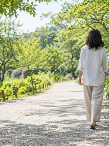 初夏の並木道をまっすぐな姿勢で歩く後ろ姿
