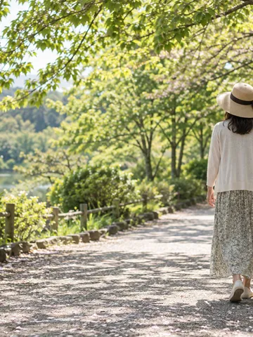 日差しの下、帽子をかぶり歩く後ろ姿
