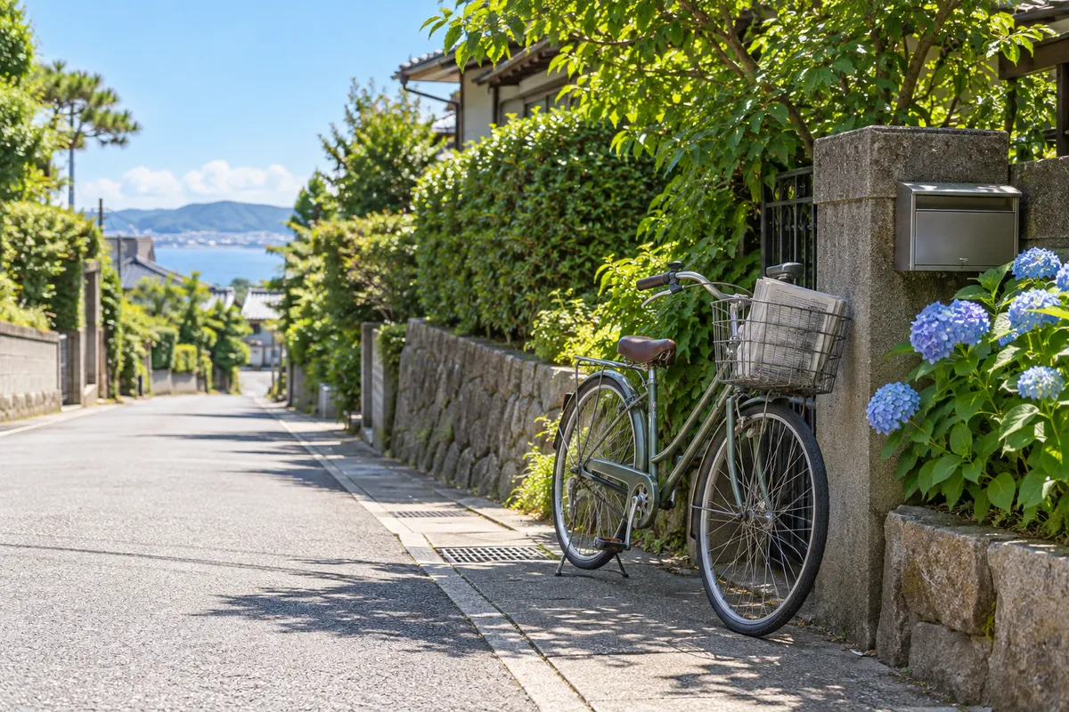 夏の昼の門前に停めた、新聞を積んだ配達用自転車