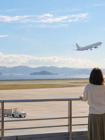 空港の展望デッキから離陸する飛行機を眺める