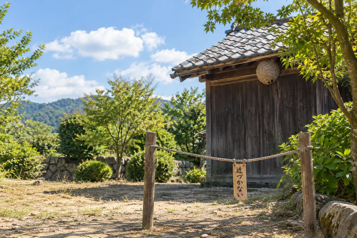 軒下の蜂の巣と「近づかない」の木札
