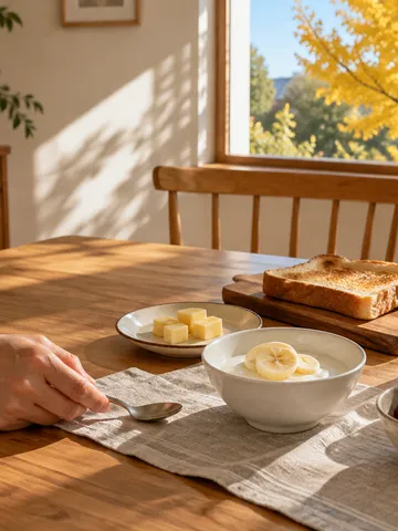 朝日の差す食卓に並ぶヨーグルトとチーズと牛乳の朝食