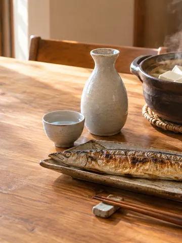 焼き魚と湯豆腐に添えた日本酒の食卓